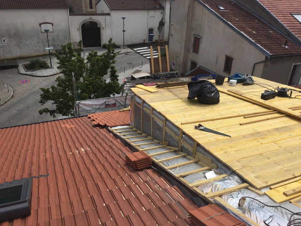 Travaux de couverture d'un toit avec un balcon sur un toit
