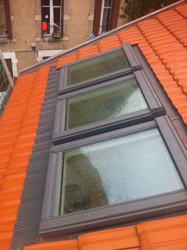 Trois Velux installés sur un toit traditionnel