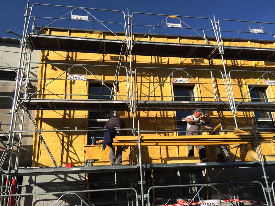 Deux ouvriers sur un échaffaudage sur un chantier d'isolation