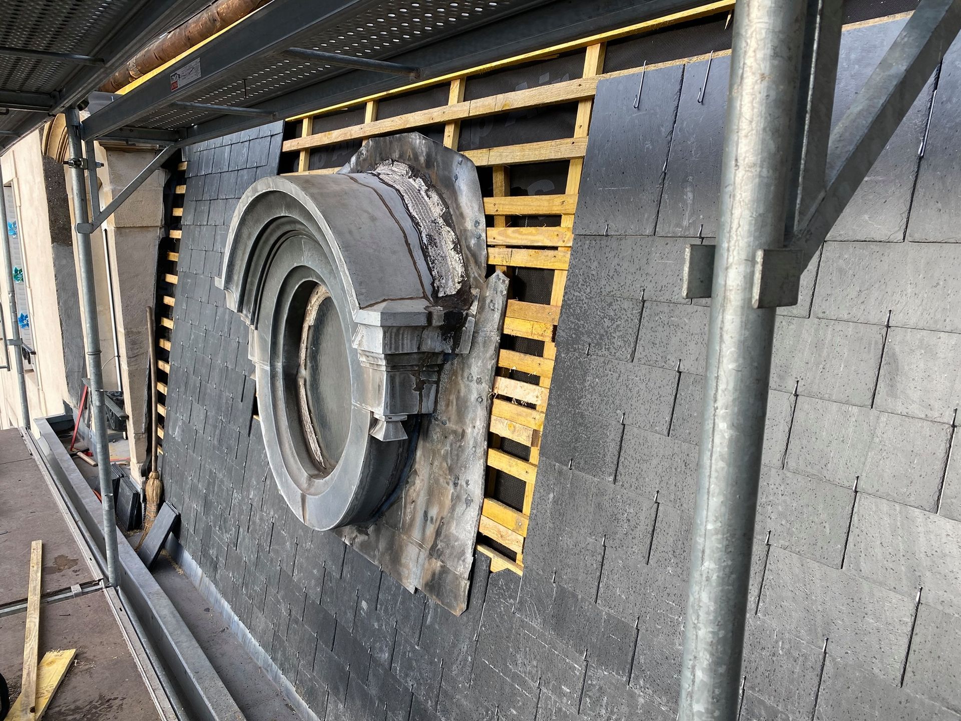 Ouvrier qui installe une fenêtre de toit depuis l'intérieur