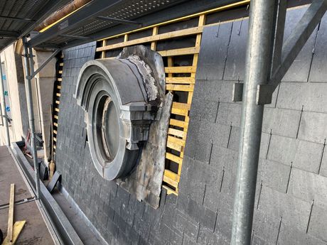 Ouvrier qui installe une fenêtre de toit depuis l'intérieur