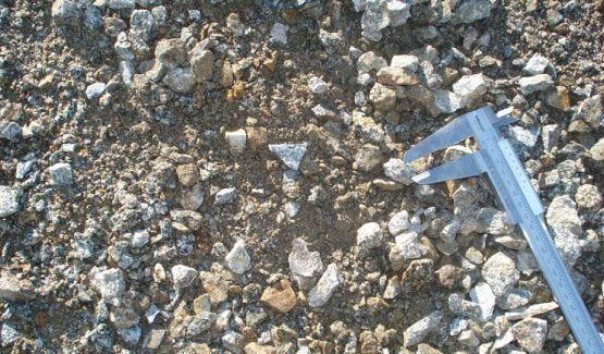 Una persona está midiendo una pila de rocas con un calibrador.