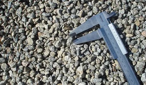 Una pinza está colocada encima de una pila de grava.