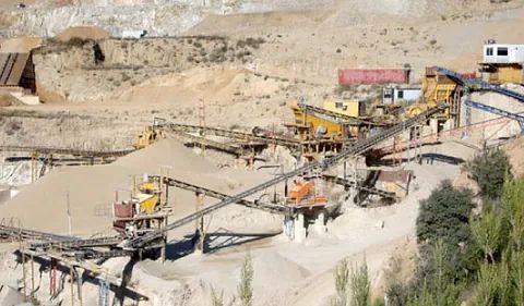 Una vista aérea de una cantera de arena con mucha maquinaria.