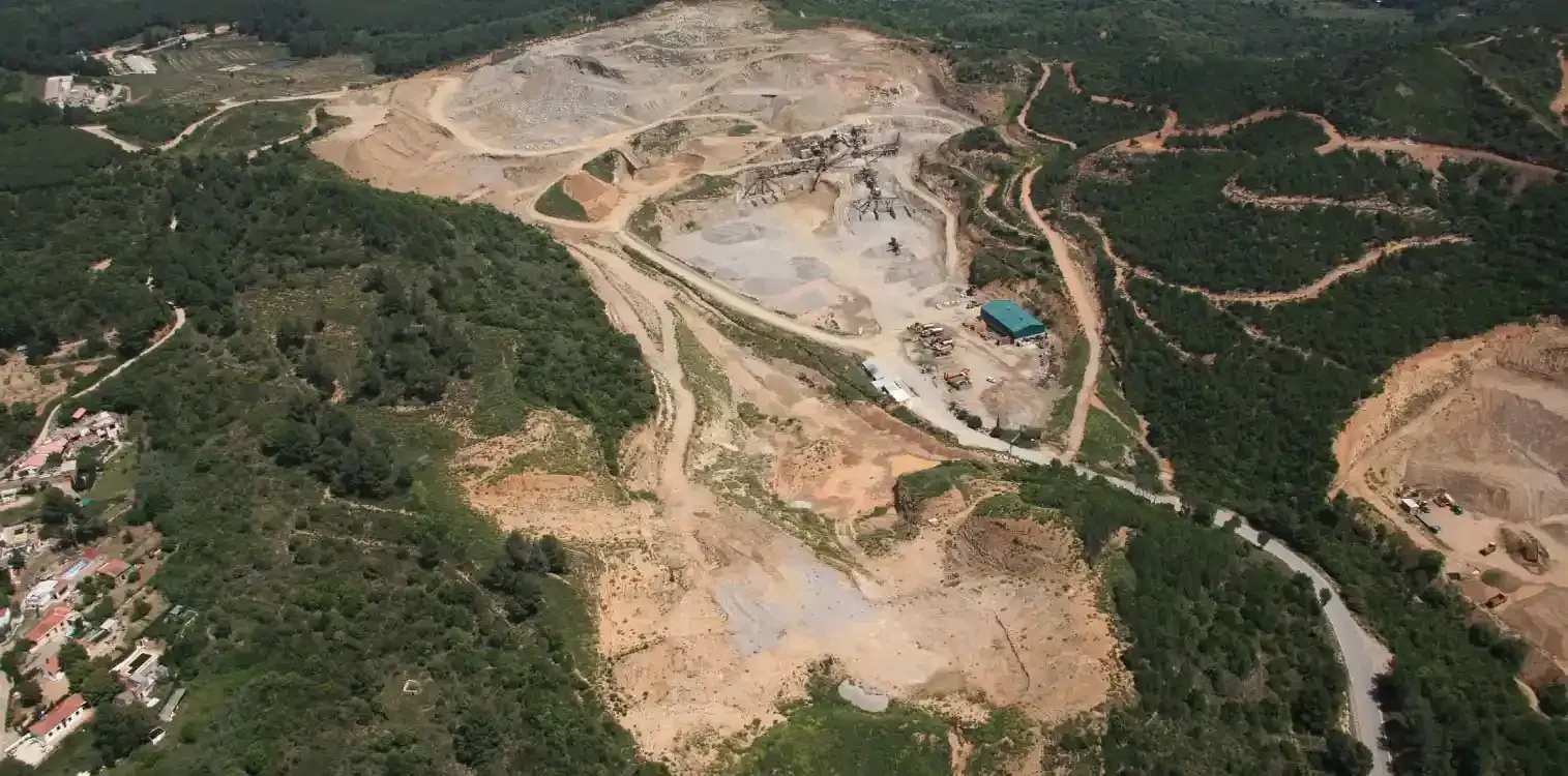 Una vista aérea de un campo de tierra rodeado de árboles.