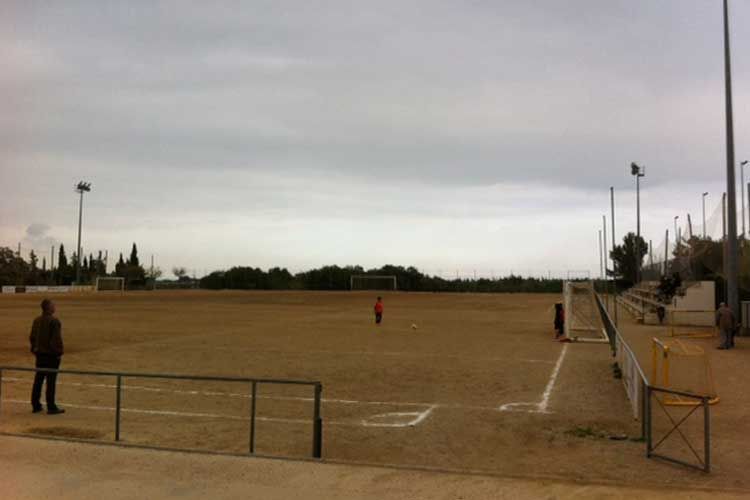 Un hombre está parado en medio de un campo de fútbol.