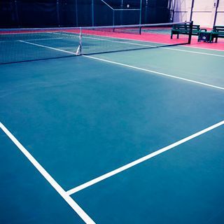 Una cancha de tenis con una red y un banco