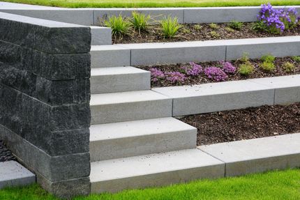 Eine Treppe, die zu einem Garten mit lila Blumen führt