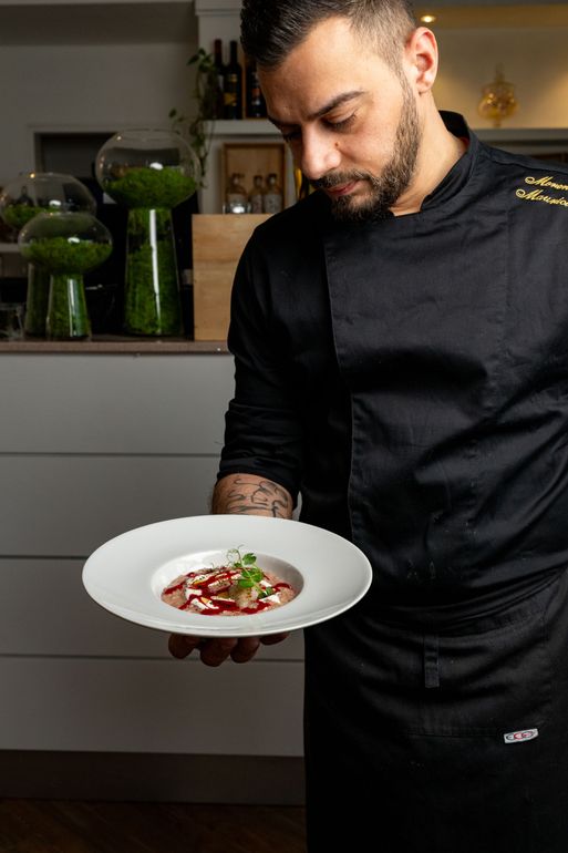 Chef Moreno Maurici  mostra un piatto signature del menù all'interno del ristorante filettè
