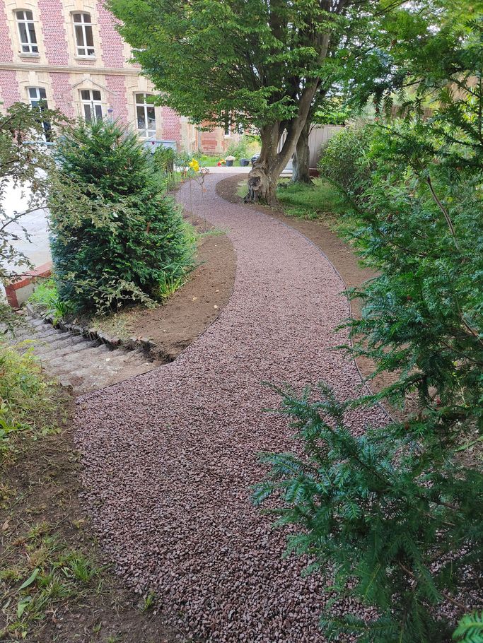 Une allée de jardin devant un manoir