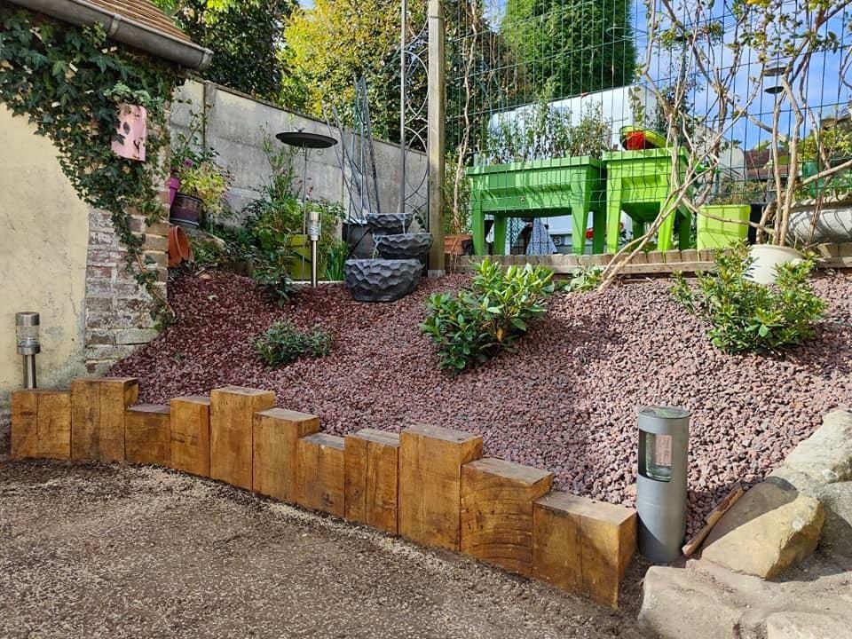 Un massif paysager en pente avec une bordure en bois