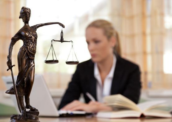 Abogada de fondo desenfocada con estatua de la justicia