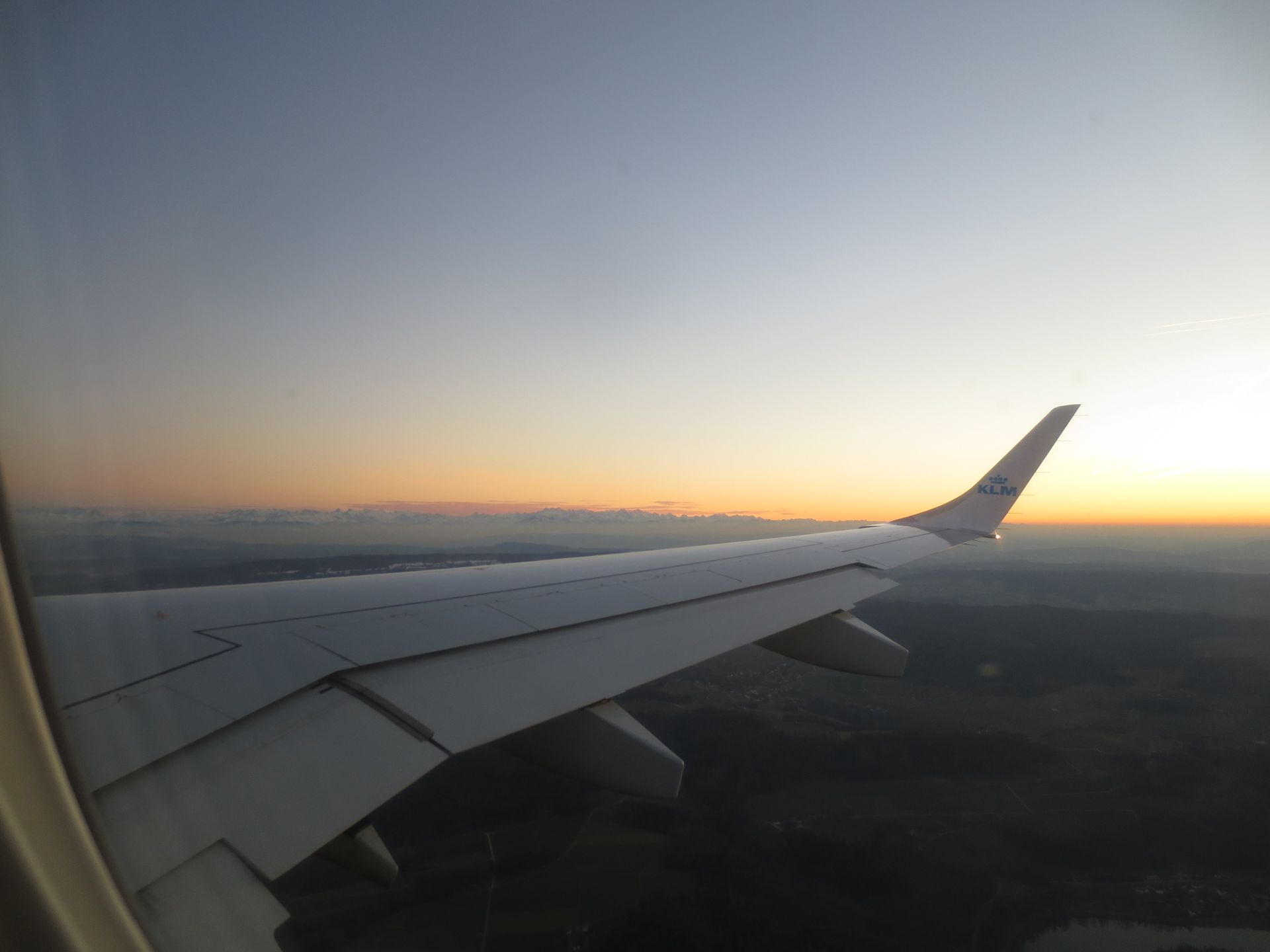 Der Flügel eines Flugzeugs, das bei Sonnenuntergang in den Himmel fliegt