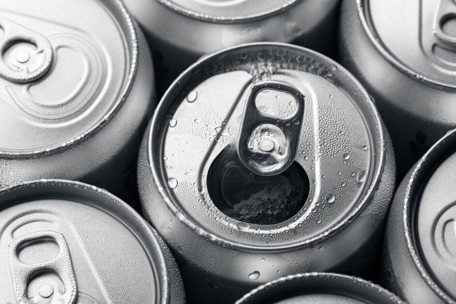 Un grupo de latas de refresco están apiladas una encima de otra.