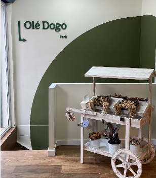 Carrito de golosinas para perros frente a una pared con el cartel 