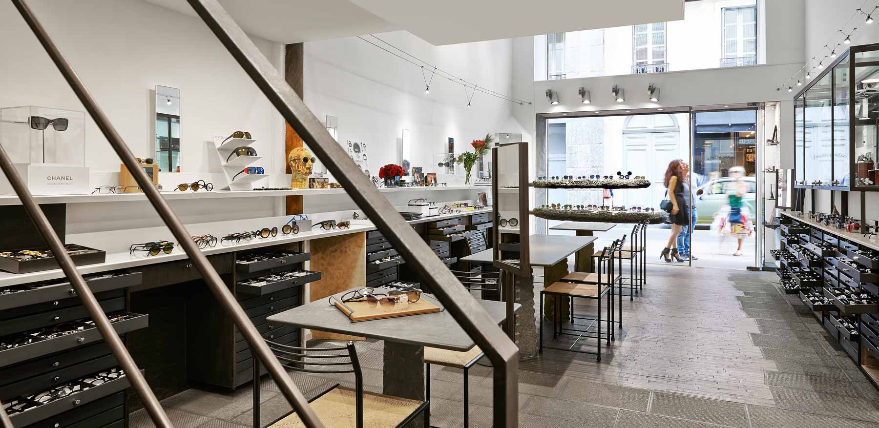 Un intérieur de magasin de lunettes avec des gens qui font du shopping, un design moderne, lumineux.