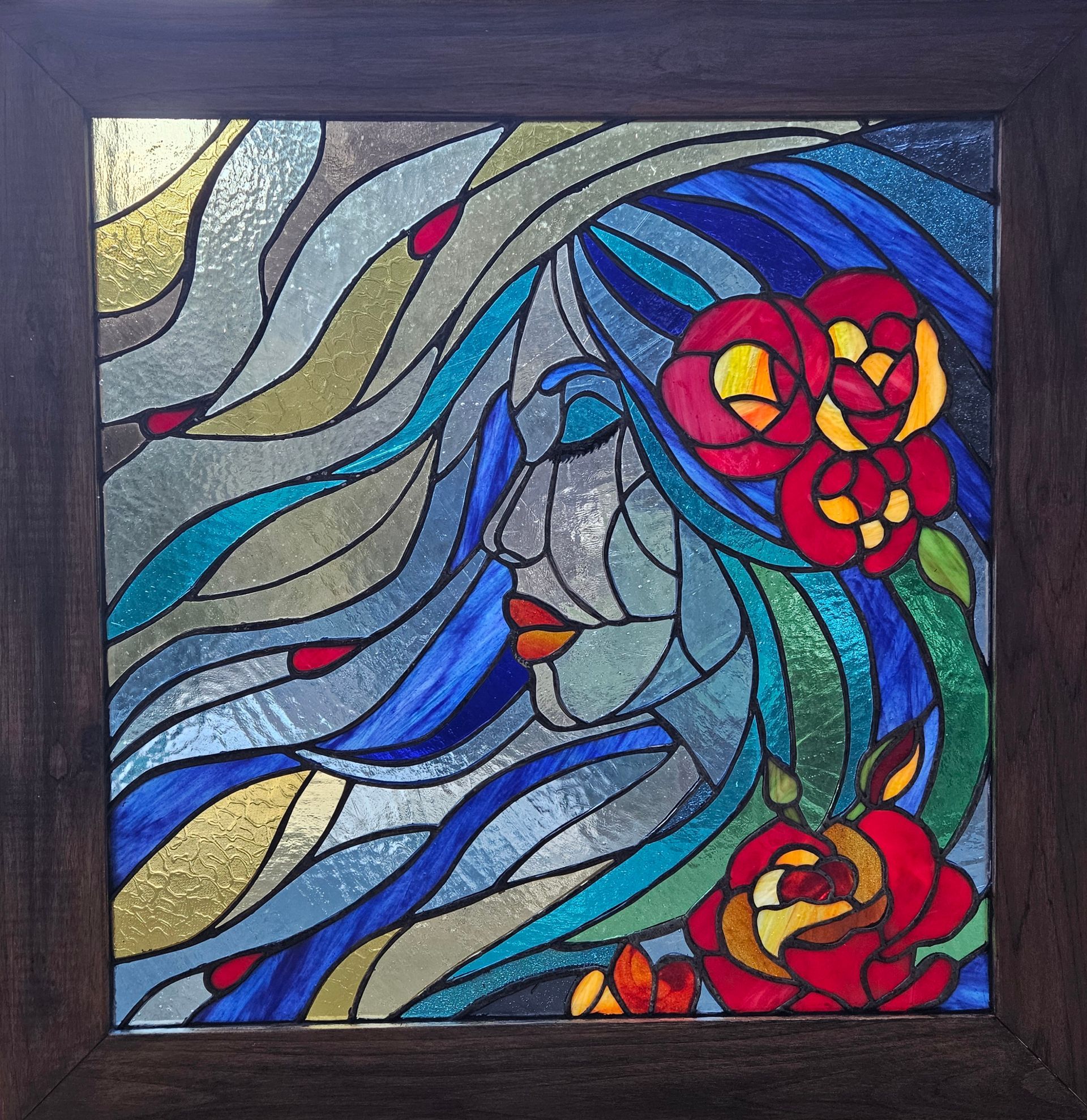 Una pintura de vidriera de una mujer rodeada de rosas.
