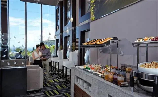 Una pareja parada frente a un buffet en un restaurante.