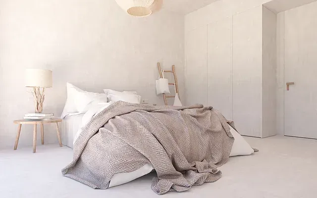 Un dormitorio con cama, mesita de noche, lámpara y escalera.