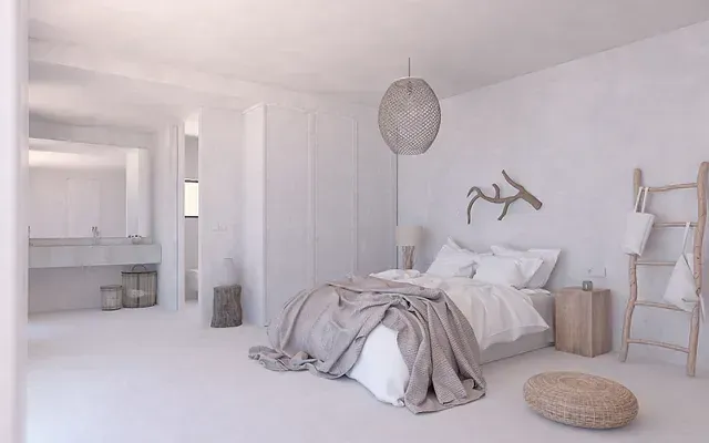 Un dormitorio con una cama y un baño al fondo.