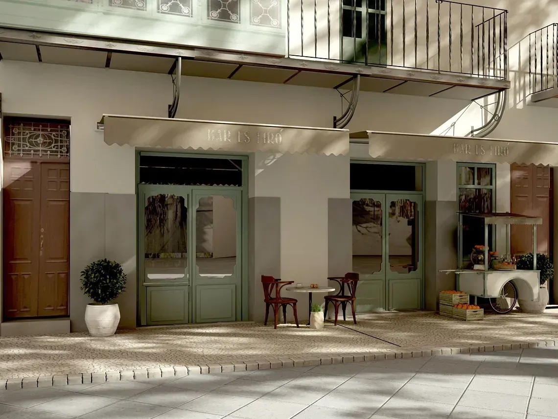 Un edificio con un balcón y mesas y sillas delante.