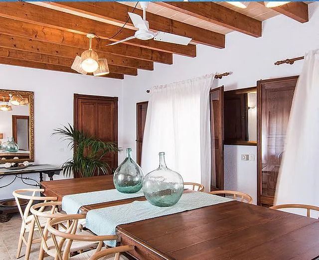 Un comedor con mesa y sillas y un ventilador de techo.