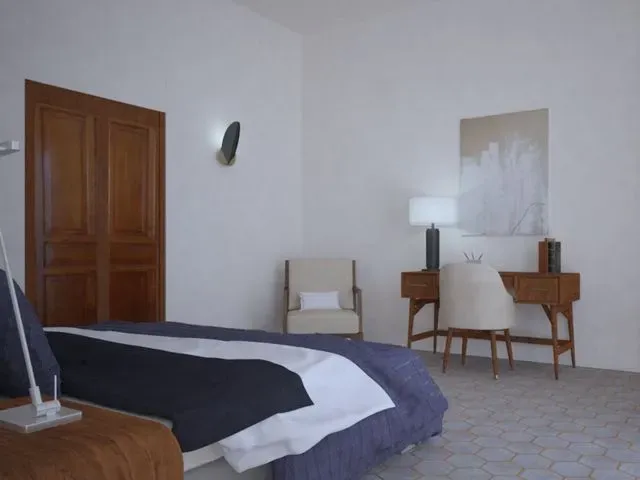 Un dormitorio con una cama, una silla y un escritorio.