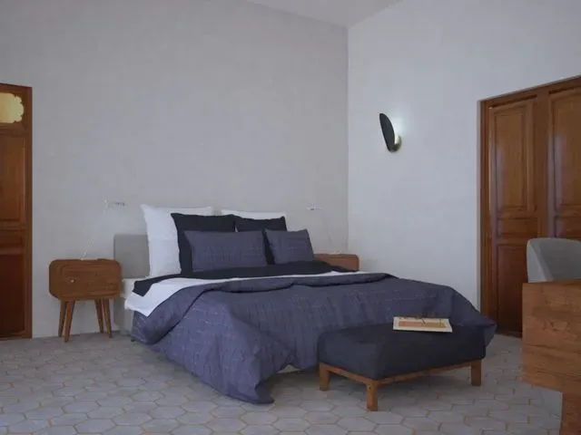 Un dormitorio con una cama grande y una otomana.