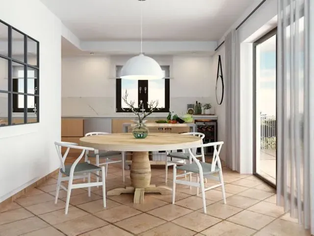 Un comedor con una mesa redonda y sillas.