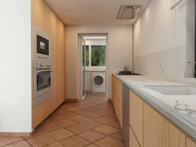 Una cocina con muebles de madera y lavadora.