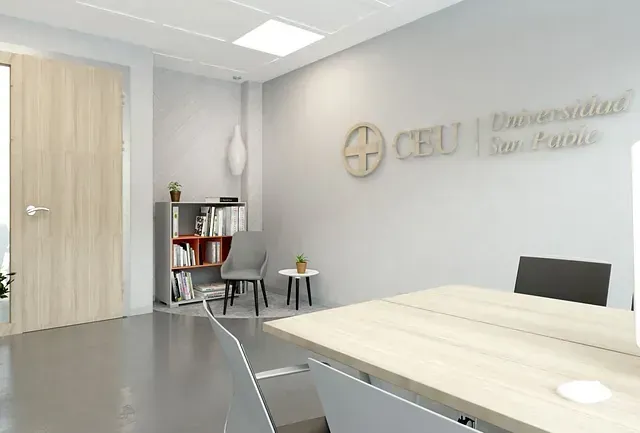 Una habitación con una mesa y sillas y un cartel en la pared que dice ceu