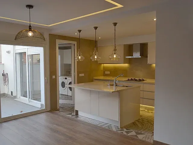 Una cocina con una gran isla en el medio de la habitación.