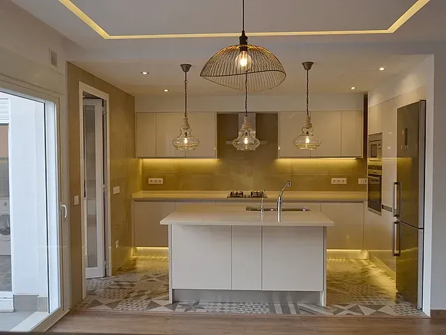 Una cocina con una gran isla en el medio de la habitación.