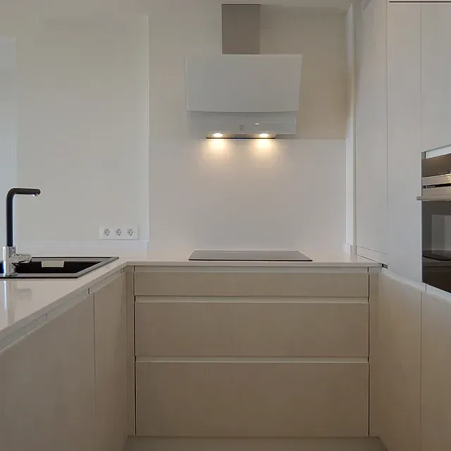 Una cocina con gabinetes blancos y un horno de estufa.