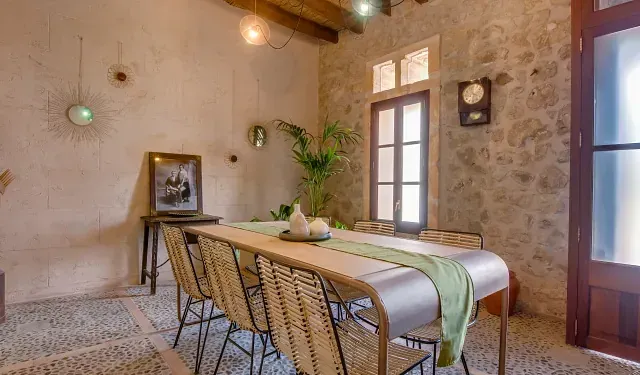 Un comedor con una mesa y sillas y un reloj en la pared.