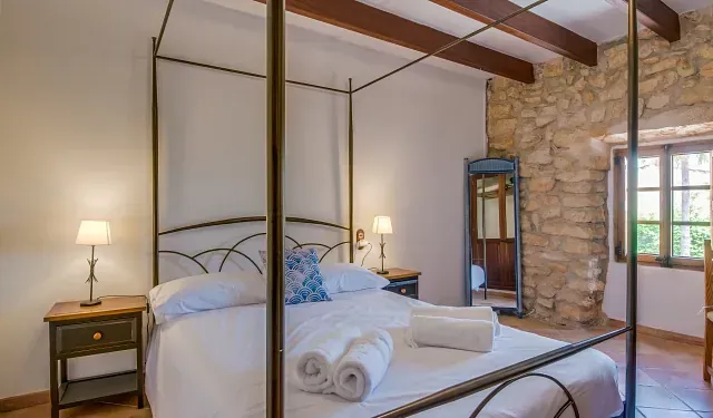 Un dormitorio con una cama con dosel y un espejo.