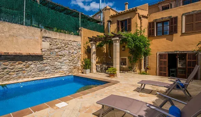 Hay una gran piscina en el patio trasero de una casa.