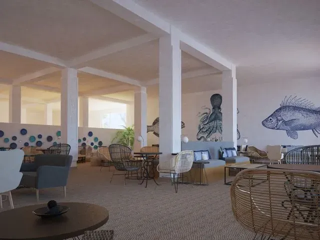 Una sala grande con mesas y sillas y un cuadro de un pez en la pared.