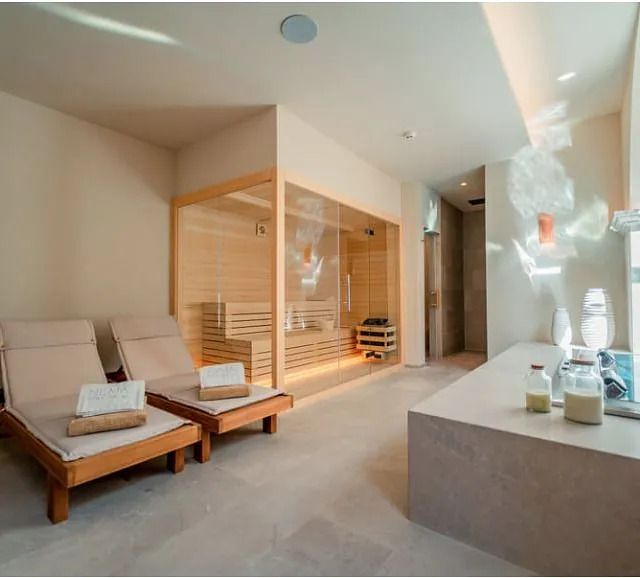 Una habitación con sillas y una sauna en ella.