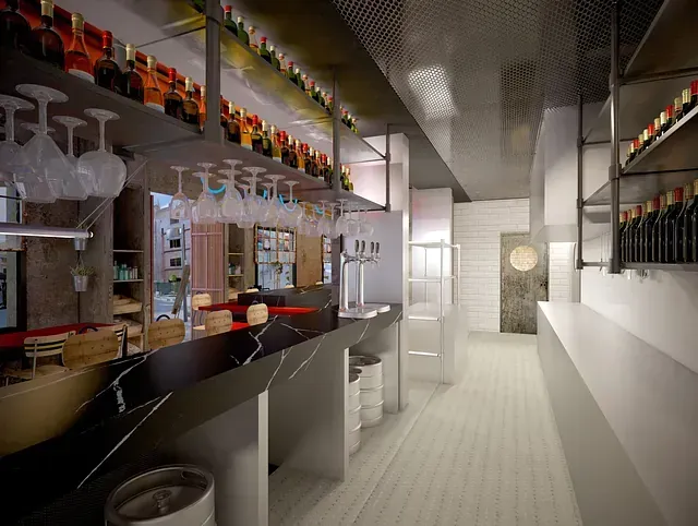 Una impresión artística de un bar con copas de vino colgando del techo.