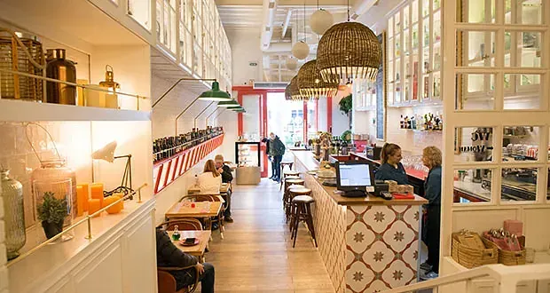 Un grupo de personas están sentadas en las mesas de un restaurante.