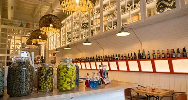 Un restaurante con muchos frascos y botellas en el mostrador.