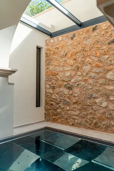 Una habitación con una pared de piedra y un suelo de cristal.
