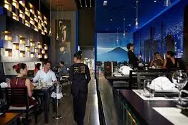 Un grupo de personas están sentadas en las mesas de un restaurante.