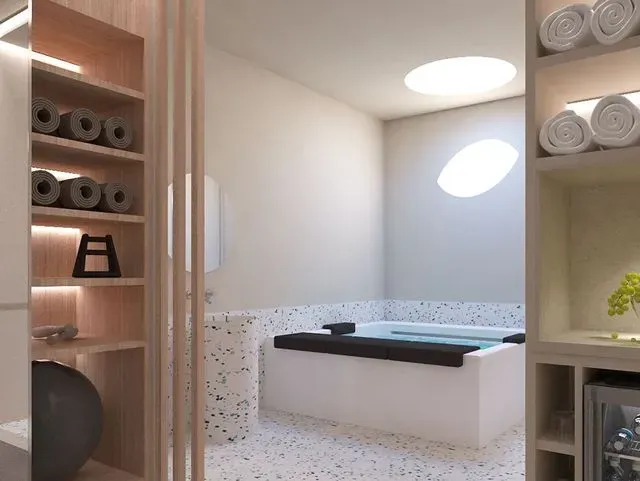 Un baño con bañera y toallas en estantes.