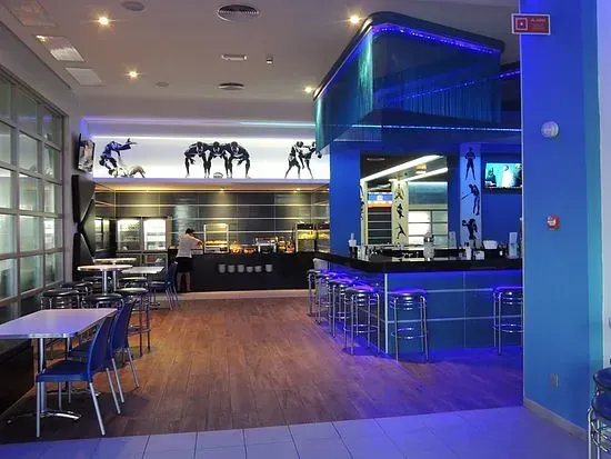 Un restaurante con mesas y sillas y una barra azul.