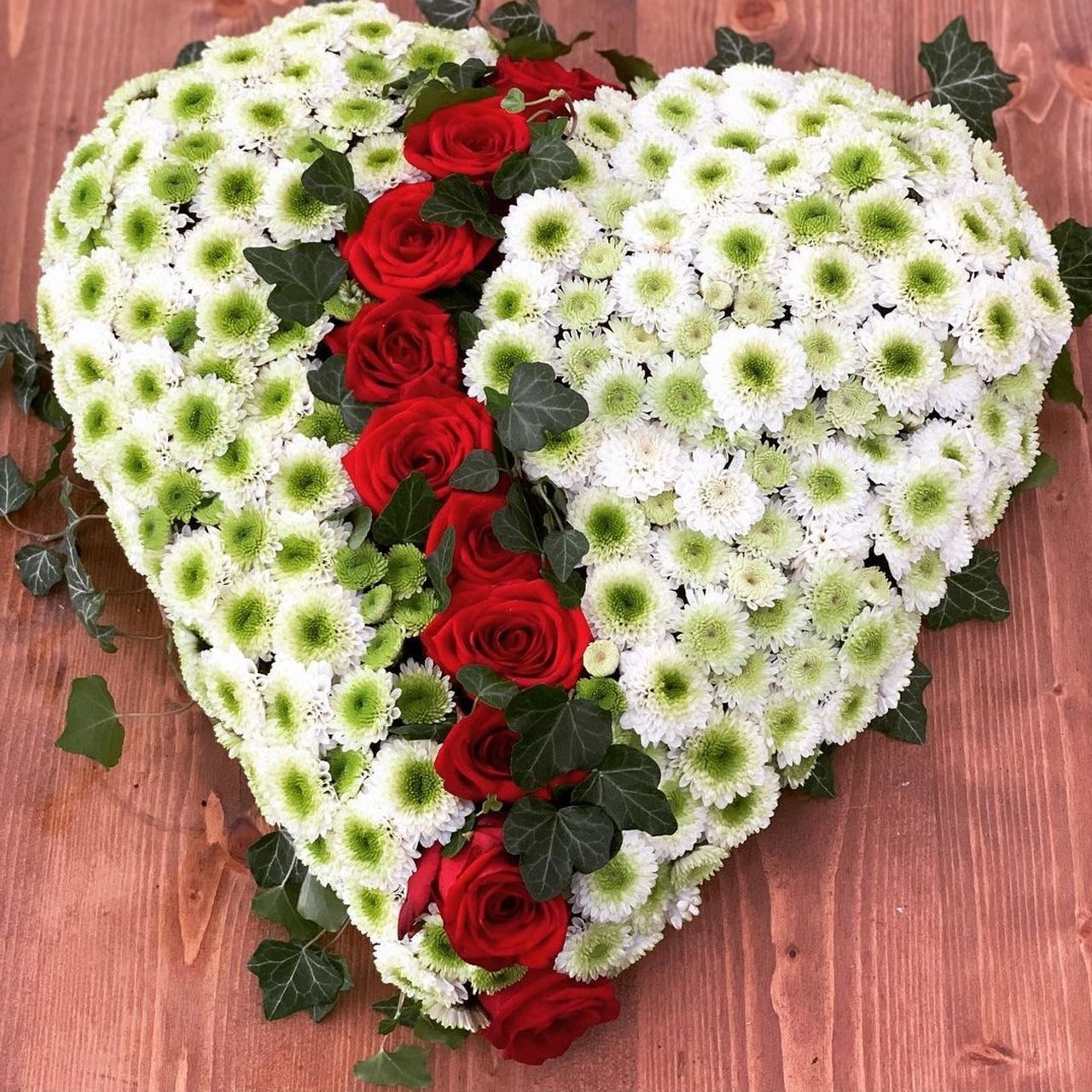 Herz aus roten Rosen und weißen Blumen