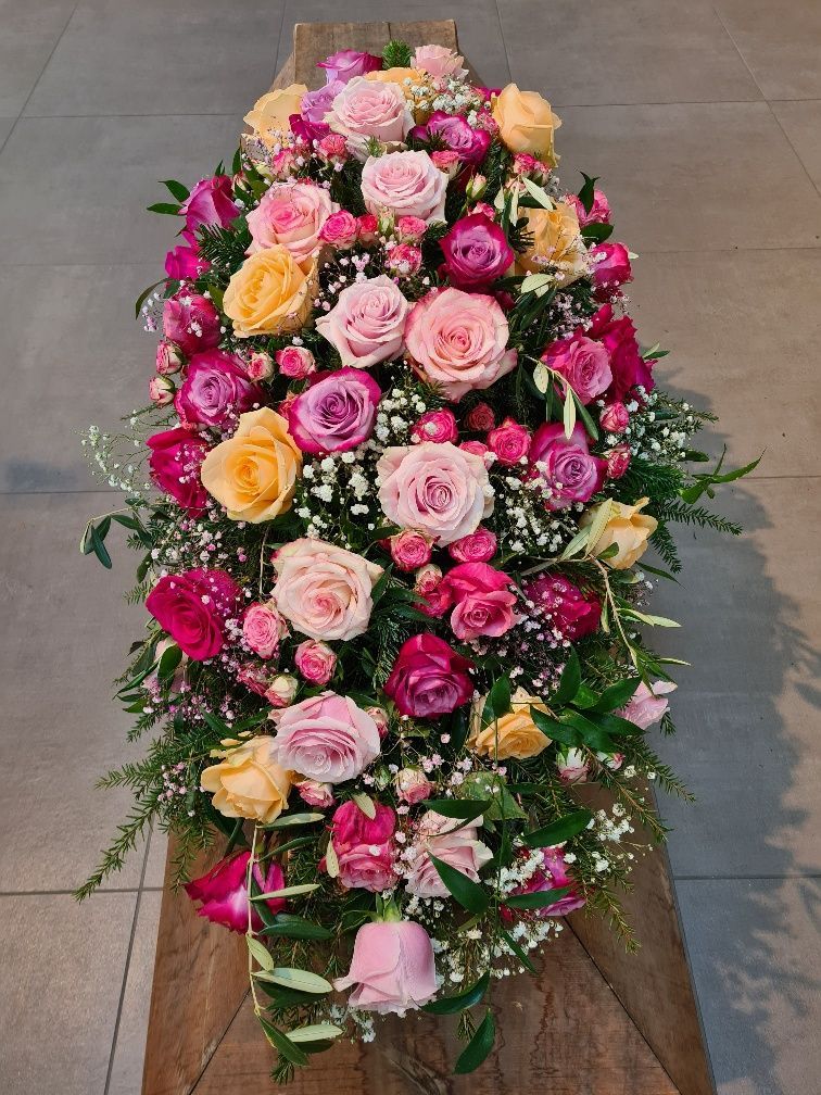 Sargbuketts aus pinken und gelben Rosen