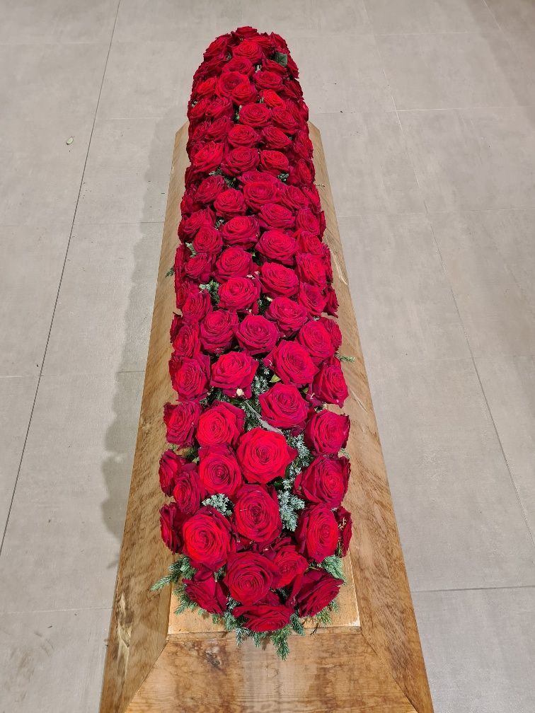 Sargbuketts mit roten Blumen