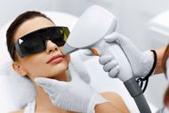 Frau erhält Laser-Gesichtsbehandlung unter Tragen einer Schutzbrille